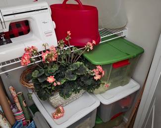 Closet shelving with sewing machine, storage totes and flowers