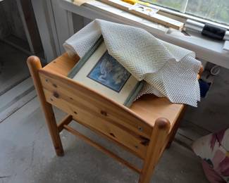 Pine desk chair with framed art and papers on top