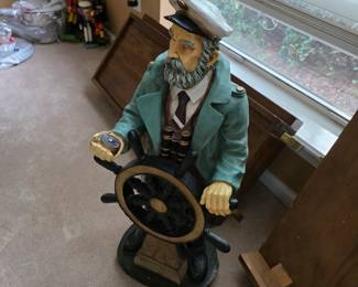 Nautical sea captain figure at ship wheel