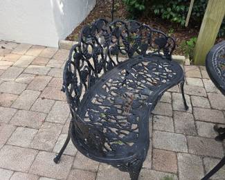 Ornate cast aluminum patio bench with floral scrollwork