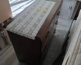 Wood dresser with lace runner and window light