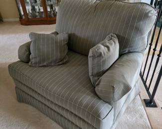 Sage green striped armchair with throw pillows
