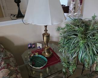 Brass table lamp with white shade on glass end table