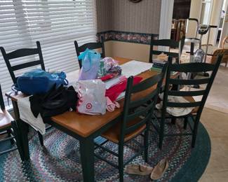 Dining table with ladder-back chairs and braided rug