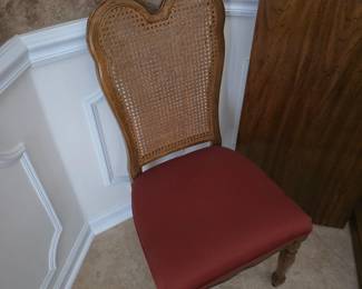 Cane-back dining chair with red upholstered seat