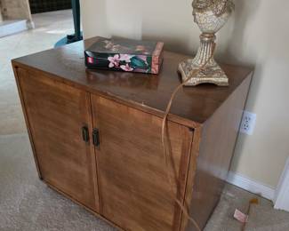Wood two-door cabinet with silver-tone table lamp