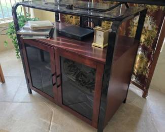 Mahogany-finish TV cabinet with glass doors and rolled area rug