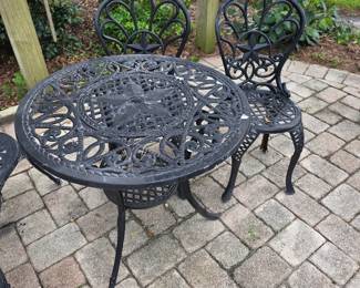 Black cast aluminum patio table and chairs with ornate pattern
