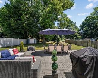 Outdoor sectional. Travertine table with a chairs the chairs are newly upholstered in great condition and a full umbrella covering the entire table.