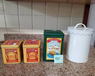 Lot of vintage kitchen storage items including two Hermes brand boxes, a green canister, and a white ceramic container with lid. Items show age and wear consistent with vintage kitchen collectibles.