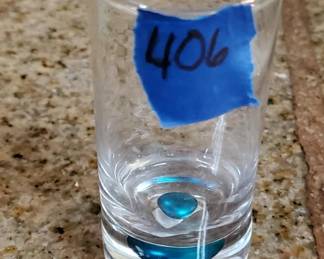 Clear glass tumbler with a blue horizontal stripe band near the base. Simple everyday glassware, likely mid-20th century.