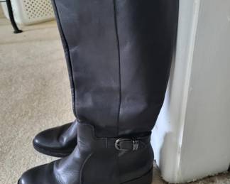 Pair of black leather knee-high boots with a buckle strap detail at the calf. The boots appear to be in good condition with minimal visible wear.