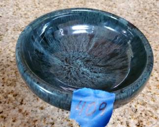 Handmade ceramic bowl with a mottled blue glaze and rustic finish. Shows signs of age and use with visible wear to the interior surface.