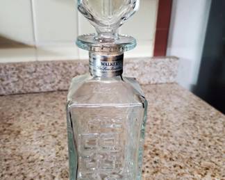 Clear glass decanter with geometric cut pattern and matching glass stopper. The piece shows traditional cut glass design typical of mid-20th century barware.