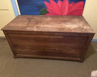 Vintage wooden storage trunk with a hinged lid and simple paneled construction. Shows age-appropriate wear and patina on the surface.