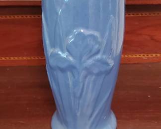 A tall blue ceramic vase with raised floral motif, likely tulips or similar flowers. The piece has a smooth glaze finish and appears to be mid-20th century production.