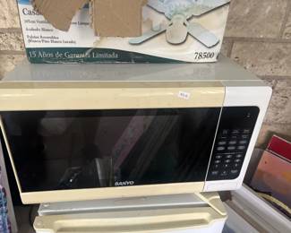 Countertop microwave oven with white exterior and black interior. Unit appears to be in working condition with visible control panel on the right side.