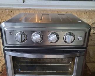 Compact countertop convection oven with stainless steel exterior and four control knobs. Features a glass viewing window and appears to be in working condition.