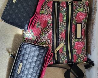 Set of three Vera Bradley quilted fabric bags in various patterns including pink floral and navy designs. Includes cosmetic pouches and a larger travel organizer with handles.