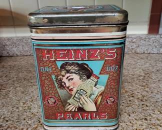 Vintage Heinz Pearls decorative tin with colorful label featuring a woman's portrait and ornate design. Metal container with hinged lid, appears to be early-to-mid 20th century.