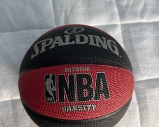 Official Spalding NBA basketball with red and black panels. Standard indoor/outdoor basketball in good condition.