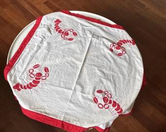 White cotton kitchen towel with red lobster print design and red trim. Shows typical wear from use.