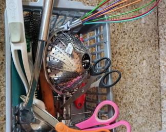 Mixed lot of craft and sewing supplies including scissors, thread, needles, and various hand tools. Items appear to be stored together in a container or drawer.