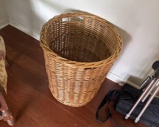 Tall cylindrical wicker waste basket with a natural tan finish. Suitable for bedroom, office, or bathroom storage.