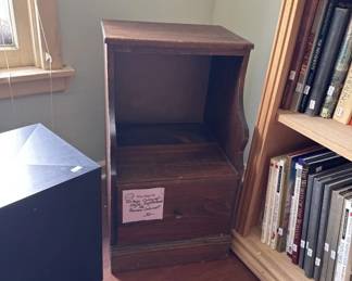 Simple wooden cabinet with open shelving and a dark finish. The piece appears to be a display or storage unit with clean lines and a modest footprint.