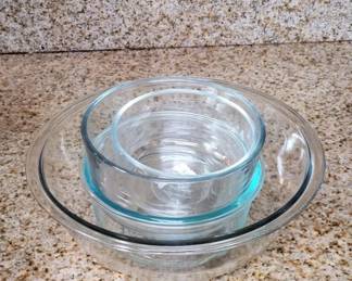 Set of two clear glass nesting bowls with Pyrex branding. The bowls feature the characteristic blue-tinted glass typical of vintage Pyrex cookware.