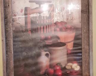 Framed print depicting a kitchen scene with cookware, produce, and vintage kitchen items. The image has a warm, muted color palette and appears to be a decorative wall art piece.