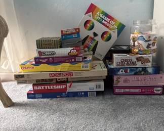 Lot of assorted board games including Monopoly, Battleship, and other classic games in various conditions. Boxes show typical wear from storage and play.