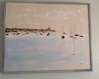 Framed photograph or print depicting a serene coastal scene with sailboats and rocky shoreline in muted tones. The image shows a minimalist composition with boats reflected in calm water.