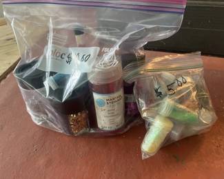 Assorted craft and hobby supplies in plastic storage bags, including beads, findings, and other small components. Appears to be a collection for jewelry making or similar crafts.