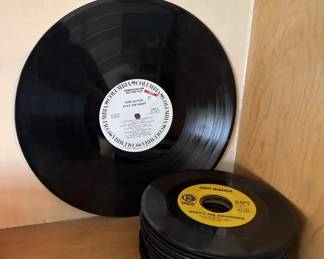 Two vinyl records including a 12-inch LP with white label and a 45 rpm single with yellow label. Both appear to be in played condition.