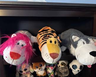 Three oversized plush animal head toys with exaggerated features, including a pink lion, orange tiger, and gray/white animal. Appears to be vintage novelty items or carnival prizes.