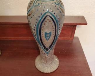 Tall ceramic vase with a cream-colored body and blue geometric Art Deco-style decoration featuring diamond and dot patterns. The vase has a pedestal base and appears to be from the early-to-mid 20th century.