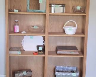Light wood shelving unit with eight open compartments, currently styled with decorative items and storage baskets. The shelves appear to be in good condition and suitable for displaying books, décor, or household storage.