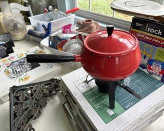 Red enameled cast iron Dutch oven with matching lid and black handles. Appears to be in good condition with vibrant enamel finish.