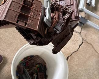 Brown plastic mold or form with multiple compartments, appears to be for making chocolates or candies. Includes what looks like a collection container or base piece.