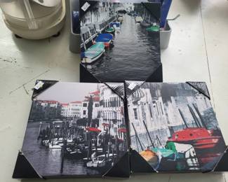 Set of three framed photographs depicting Venetian canal scenes and street views. The prints appear to be mounted in simple frames suitable for wall display.