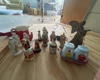Assorted Christmas decorative figurines and ornaments, including Santa figures, trees, and snow globes in various sizes and styles.