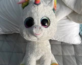 Soft white plush unicorn with large round eyes, pink nose, and colorful horn details. A child's stuffed animal in good condition.