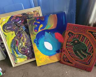 Three colorful decorative wall pieces including abstract painted panels and geometric designs in bright colors. Items appear to be modern art or craft projects.