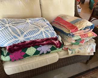 Several vintage quilts in various conditions.