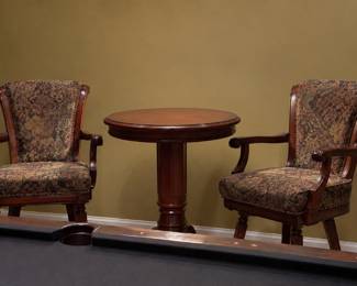 wood pedestal table paired with two upholstered armchairs