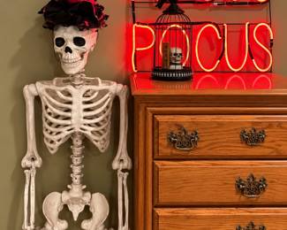 Several life size skeletons, neon light up sign