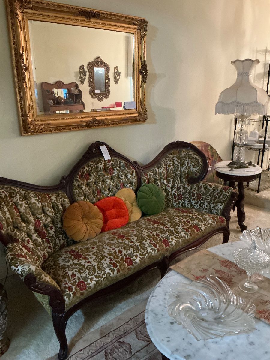 The sofa is a rococo revival, the tables or Kimball marble tables the mirror on the wall it is a vintage gold baroque or Hollywood Regency mirror beveled very heavy
