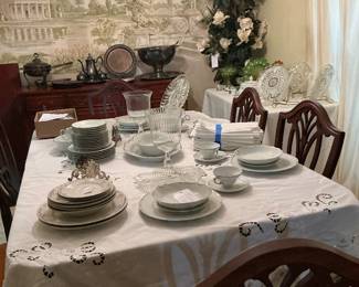A mixture of China different patterns sitting on a Duncan fight table that comes with six chairs and two extra leaves