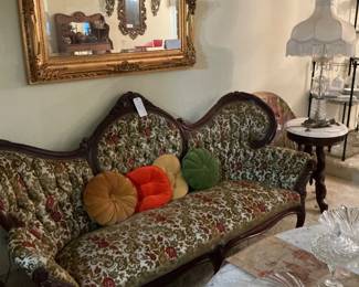 The sofa is a rococo revival, the tables or Kimball marble tables the mirror on the wall it is a vintage gold baroque or Hollywood Regency mirror beveled very heavy